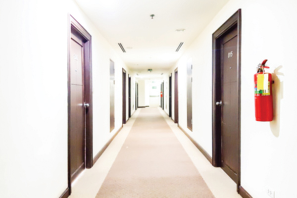Hallway of hotel with fire extinguisher to the right